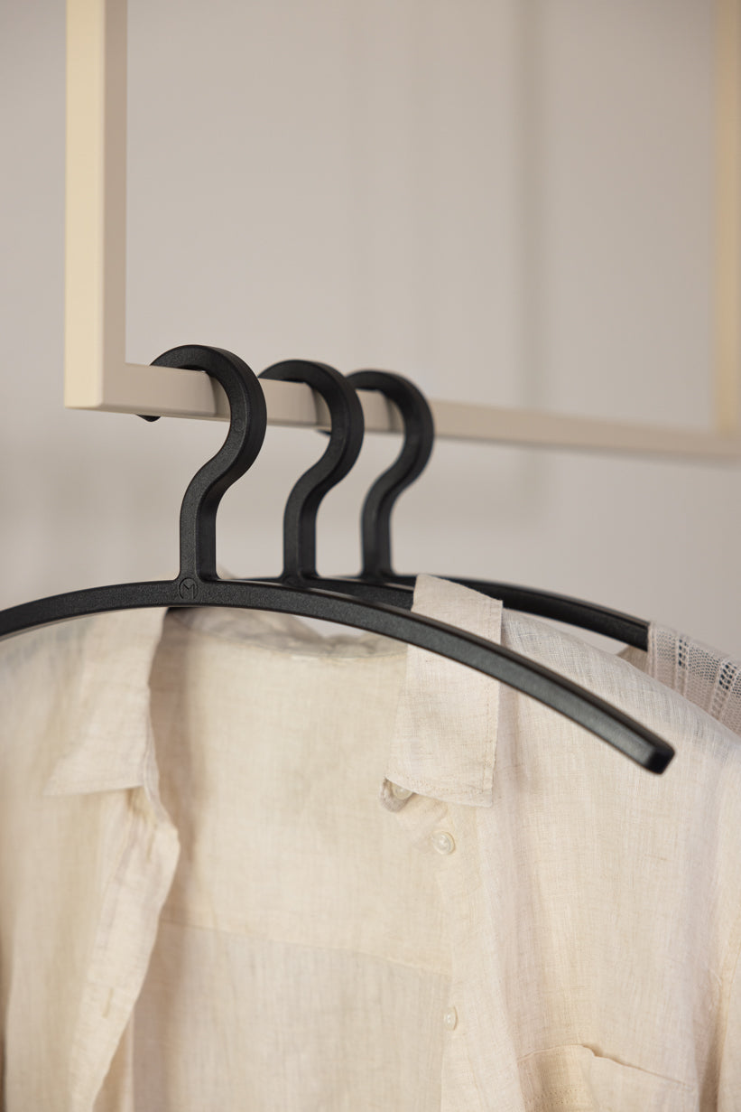 Schwarze FAY Kleiderbügel im 3er Set an einer Garderobe mit Bluse