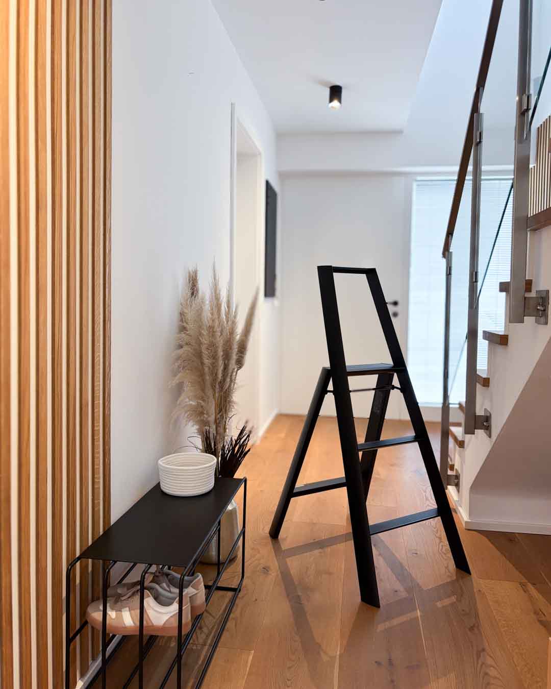 Kategorie Design Leitern mit ALVA Leiter aus schwarzem Stahl im modernen Flur neben Schuhbank und Holzlamellenwand