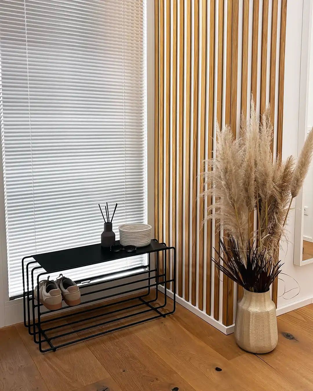 Design Standregal aus Stahl in Schwarz mit vier Ablagen, dekoriert mit Körben, Vase und Wohnaccessoires im modernen Wohnzimmer