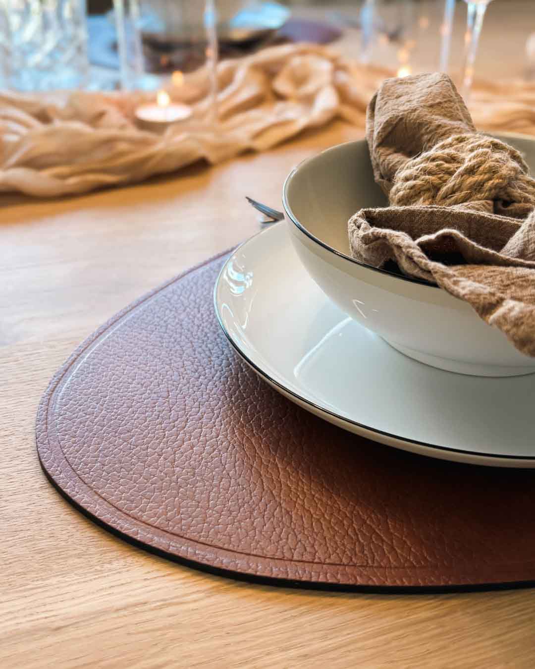 MATS braune Design-Unterlage aus recyceltem Leder auf einem gedeckten Holztisch mit Schale